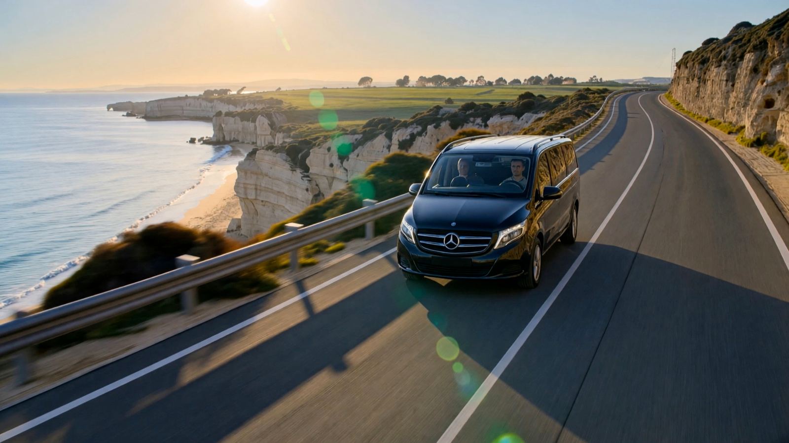 Mercedes V-Class preto numa estrada costeira sobre uma praia do Algarve ao fim da tarde